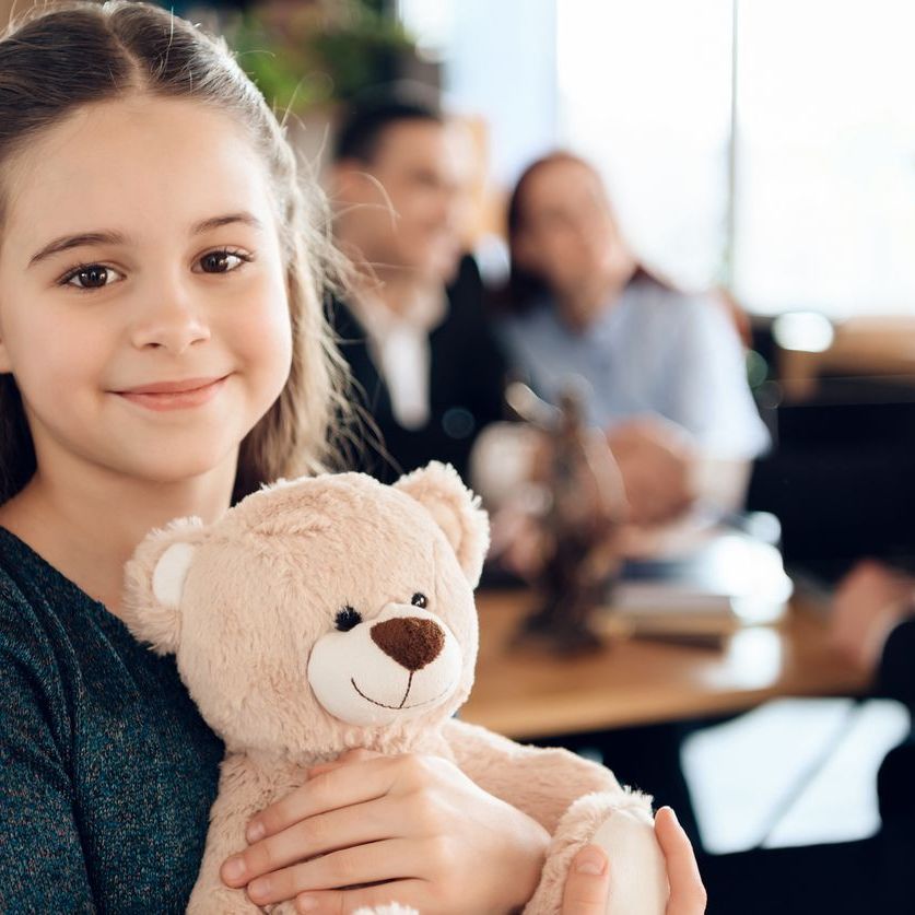 Beautiful girl with parents stands in the office.